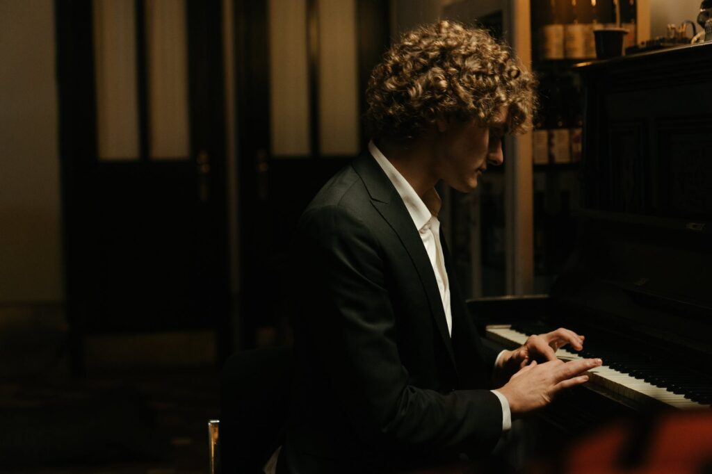 Top 100 Piano Bar/Dueling Piano Songs man in black suit jacket using black smartphone
